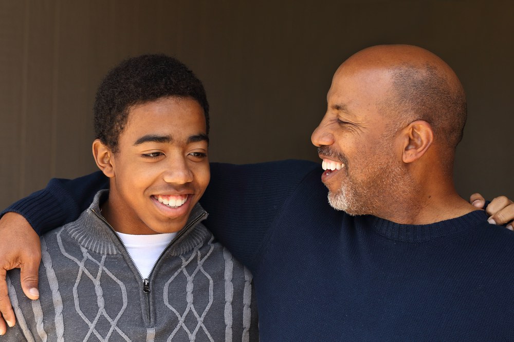 Af Am Father and Son Smiling and Talking